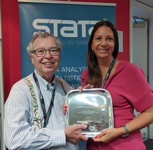 Teresa Timberlake accepting a presentation from Bill Gould, President of StataCorp at 2016 London Stata Users Group Meeting